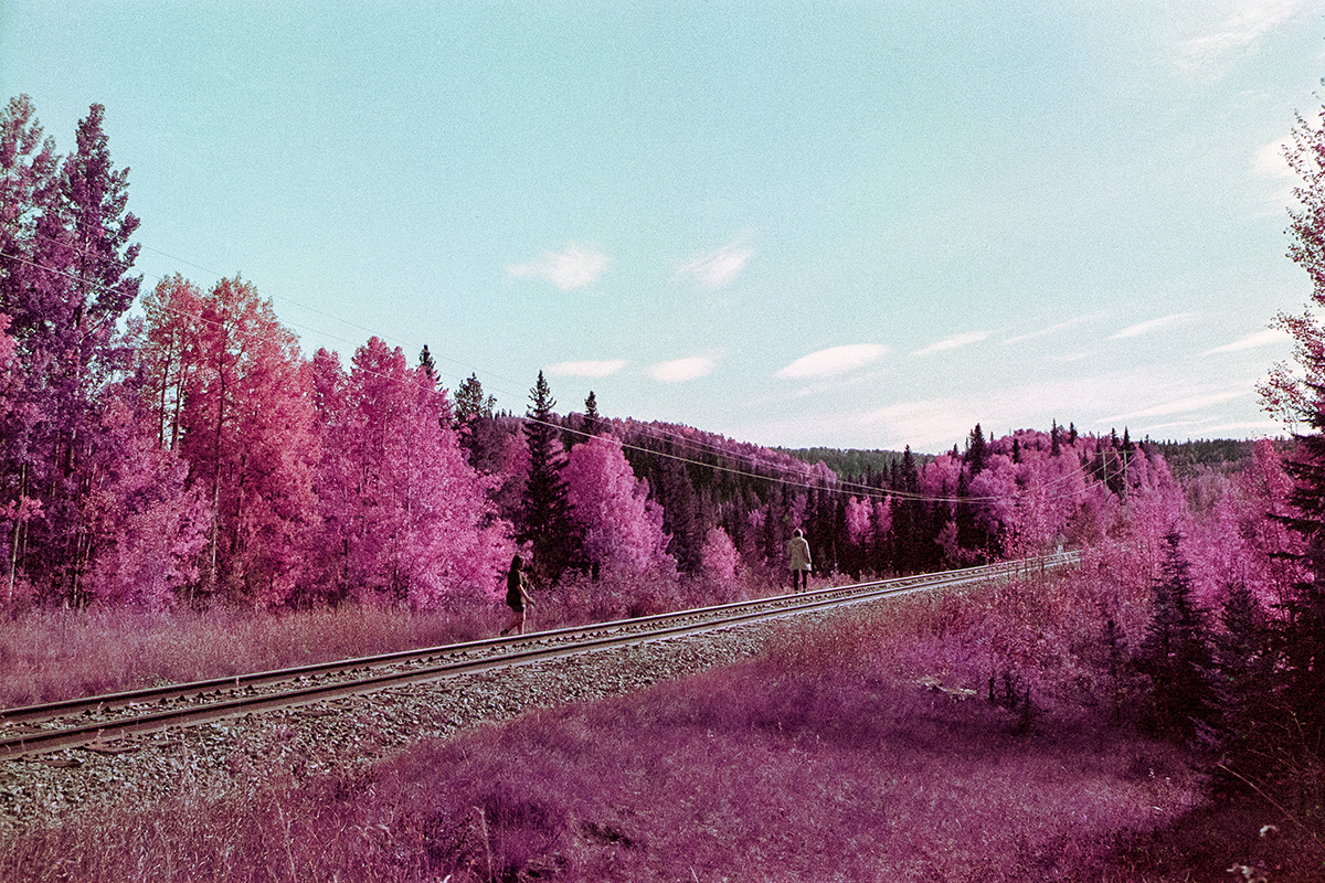 two people walking on railway track